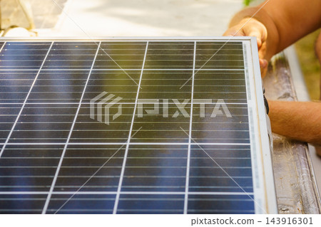 Working on solar panel installation on a roof of caravan in bright sunlight with tools nearby Working on solar panel installation on a roof of caravan in bright sunlight with tools nearby 143916301