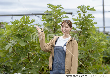 一位女農夫面帶微笑,直視鏡頭,介紹她的無花果園。 一位女農夫面帶微笑,直視鏡頭,介紹她的無花果園。 143917089