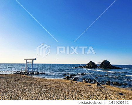 以藍天碧海為背景的海岸景觀,白色鳥居和夫妻岩(Meoto Iwa)格外引人注目。 以藍天碧海為背景的海岸景觀,白色鳥居和夫妻岩(Meoto Iwa)格外引人注目。 143920421