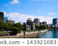 The Hiroshima Atomic Bomb Dome and Motoyasu River, surrounded by blue skies and greenery. 143921083
