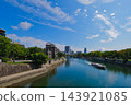 A sightseeing boat sailing along the Motoyasu River under a blue sky, near the Hiroshima Atomic Bomb Dome. 143921085
