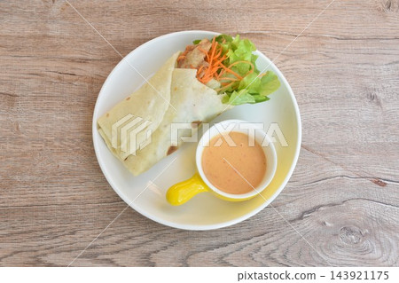 roti flour wrap grilled chicken with fresh vegetable salad dressing spicy mayonnaise cream sauce on plate 143921175