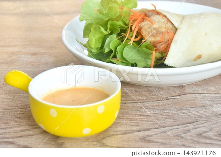roti flour wrap grilled chicken with fresh vegetable salad dressing spicy mayonnaise cream sauce on plate roti flour wrap grilled chicken with fresh vegetable salad dressing spicy mayonnaise cream sauce on plate 143921176