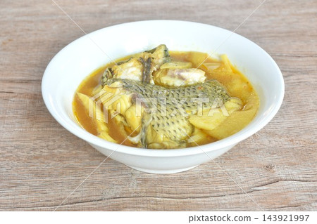 boiled red mango fish with pickled bamboo shoot in spicy and sour yellow curry soup Thai southern food on bowl boiled red mango fish with pickled bamboo shoot in spicy and sour yellow curry soup Thai southern food on bowl 143921997