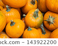 View of a pile of bright orange pumpkins with textured stems, ideal for autumn harvest, Halloween decorations, seasonal markets, cooking, and fall-themed backgrounds and displays. 143922200