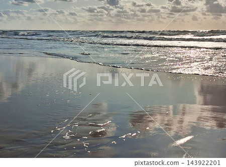 Sunset on the beach near beautiful sea in the evening. Yellow sunlight. Vacation in Ostend, Belgien. Nature background. Sunset on the beach near beautiful sea in the evening. Yellow sunlight. Vacation in Ostend, Belgien. Nature background. 143922201