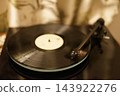 A record player and a spinning record viewed from above. 143922276