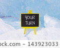 Your turn words symbol. Concept words Your turn on beautiful black blackboard. Beautiful blue ice background. Business your turn motivational support concept. Copy space. 143923033