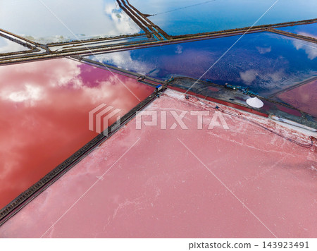 Salt extraction across evaporation ponds divided by narrow embankments at a coastal saltworks Salt extraction across evaporation ponds divided by narrow embankments at a coastal saltworks 143923491