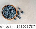 Fresh ripe blueberries in wooden bowl on a light gray textured background. Healthy organic food 143923737