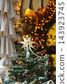Christmas tree with white star, ornaments and warm fairy lights, festive illuminated background 143923745