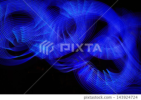 Blue neon light painting forming abstract waves in long exposure Blue neon light painting forming abstract waves in long exposure 143924724