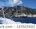View of beautiful Amalfi town, Campania, Italy. Amalfi coast is most popular travel and holiday destination in Europe. Amalfi cityscape on coast line of mediterranean sea - big yacht 143925602
