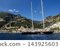 View of beautiful Amalfi town, Campania, Italy. Amalfi coast is most popular travel and holiday destination in Europe. Amalfi cityscape on coast line of mediterranean sea - big yacht 143925603