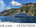 View of beautiful Amalfi town, Campania, Italy. Amalfi coast is most popular travel and holiday destination in Europe. Amalfi cityscape on coast line of mediterranean sea - big yacht 143925604