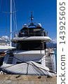 Luxury white motor yacht moored in a marina on a sunny day, with sailing boats, a cruise ship, clear blue sky and turquoise Mediterranean sea. 143925605