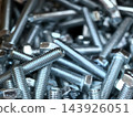 Silver machine bolts gather in a quiet industrial close-up 143926051