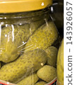 Pickled cucumbers glowing in a clear glass jar 143926057