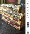 Layered berry cake dusted with dark poppy seeds 143926059