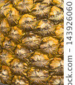Golden pineapple skin revealing a rugged tropical pattern 143926060