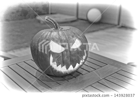 Carved pumpkin jack-o'-lantern with jagged teeth and triangular eyes on wooden table under soft ambient light, black and white closeup composition of spooky autumn decoration for Halloween party Carved pumpkin jack-o'-lantern with jagged teeth and triangular eyes on wooden table under soft ambient light, black and white closeup composition of spooky autumn decoration for Halloween party 143928037