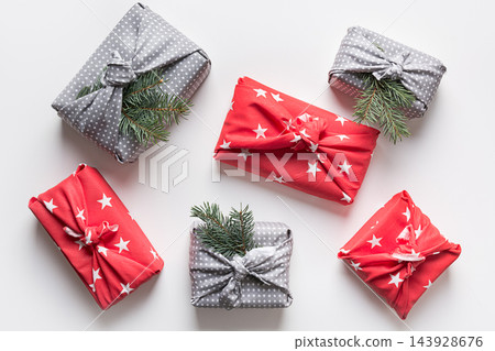 Christmas gifts wrapped in red and grey textile. 143928676