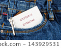 A paper note with the words discipline versus distraction and a pen rests in a jeans pocket on a denim surface 143929531