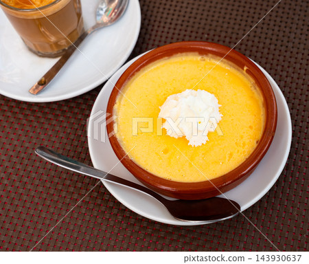 Velvety mango mousse topped wit whipped cream in clay bowl Velvety mango mousse topped wit whipped cream in clay bowl 143930637