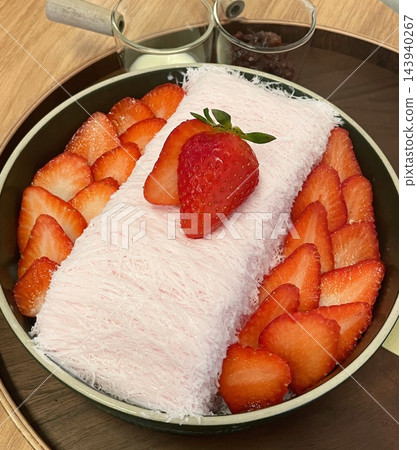 Soft and fluffy strawberry bingsu with finely shaved ice, sweet strawberry syrup, and fresh strawberry slices. A refreshing and delightful Korean dessert, perfect for a cool and fruity treat. Soft and fluffy strawberry bingsu with finely shaved ice, sweet strawberry syrup, and fresh strawberry slices. A refreshing and delightful Korean dessert, perfect for a cool and fruity treat. 143940267