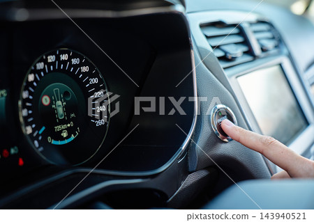 Close-up of finger pressing car engine start button Close-up of finger pressing car engine start button 143940521