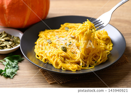 Pumpkin capellini pasta topped with grated parmesan cheese and pumpkin seeds Pumpkin capellini pasta topped with grated parmesan cheese and pumpkin seeds 143940921