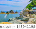 A summer scene captured on a sunny day in Futamiura, showing a stone frog standing in front of the Amano-Iwato cave, with the Meoto-iwa rocks of Ise Bay in the background. A summer scene captured on a sunny day in Futamiura, showing a stone frog standing in front of the Amano-Iwato cave, with the Meoto-iwa rocks of Ise Bay in the background. 143941198