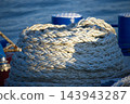 Heavy White Nautical Rope Coiled on Port Dockside Cleat in Sunny Maritime Environment 143943287
