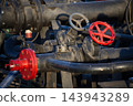 Industrial Pipe Valves and Red Pressure Flange Mechanism on Oil Refinery Equipment 143943289