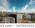 Panoramic modern city skyline with highrise buildings, coastal horizon, glass facades, downtown streets, and clear blue sky above vibrant waterfront metropolis, with city, skyline, highrise 143943434