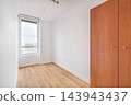 Empty bright interior room with wooden floor, large window, light walls, and built-in wardrobe, filled with natural daylight for clean minimal home design, with room, empty, bright, interior detail 143943437