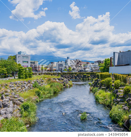富士宮市神田川沿岸的夏日景色，清澈的河水和城市景觀，湛藍的夏日天空和朵朵白雲（1:1 寬高比，正方形）（靜岡縣） 143945054