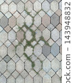 Concrete paving stone pattern with grass growing between weathered blocks 143948832