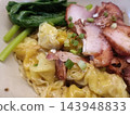 Pork, dumpling, noodle, scallion and vegetable served together in bowl 143948833