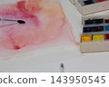Watercolor painting in progress on a white studio desk with brush and palettes 143950545