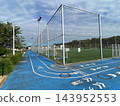 A blue running track and grounds attached to the sports facility. 143952553