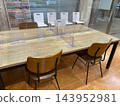 A large wood-grain table and workspace separated by acrylic panels. 143952981