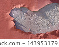 Peeling red paint layer exposing cracked concrete wall texture. Weathered damaged urban building facade 143953179