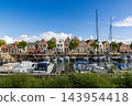 Wide angle coastal digital publication of harbor marina historic Dutch brick houses sailboats motorboats blue sky Veere Zeeland Netherlands European travel maritime heritage commercial 143954418
