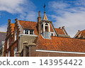 Close up coastal digital publication of historic roof tiles brick chimneys bell turret traditional architecture blue sky Veere Zeeland Netherlands European travel maritime heritage commercial 143954422