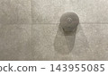 Stainless steel toilet paper dispenser on tiled wall 143955085
