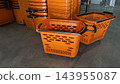 Orange plastic shopping baskets in supermarket 143955087