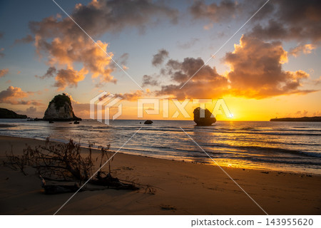 沖繩縣西表島:美麗的戶鞠海灘和沐浴在夕陽下的獨特岩石地形。 沖繩縣西表島:美麗的戶鞠海灘和沐浴在夕陽下的獨特岩石地形。 143955620