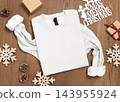Blank white folded sweatshirt mockup near rustic Christmas decor on wood. Holiday template 143955924