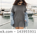 Washed grey shirt mockup, young woman on a boat, front view, copy space. Summer coastal lifestyle 143955931